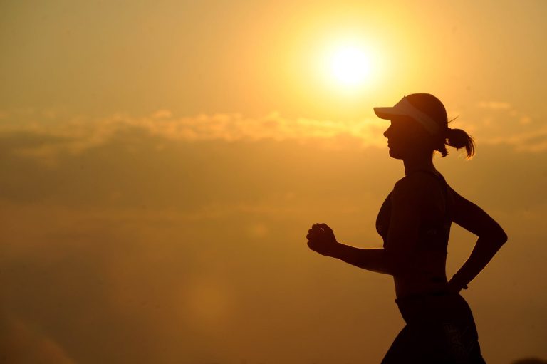 woman with white sunvisor running ayurveda